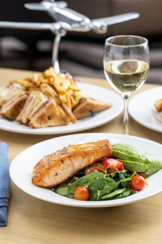 a table with two plates of food and a glass of wine at Sheraton Suites Chicago O'Hare in Rosemont