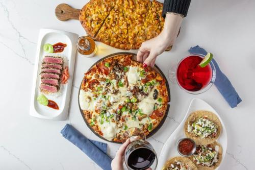 a table topped with a pizza and other food at Sheraton Suites Chicago O'Hare in Rosemont
