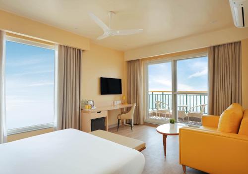 a hotel room with a bed and a desk and window at Bloom Boutique - Rishikesh Hills in Rishīkesh