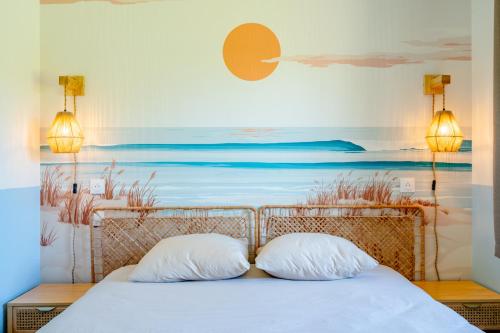 zwei Kissen auf einem Bett mit einem Gemälde an der Wand in der Unterkunft Gite La Goutte d'eau - Baby foot - 6 personnes LITS King & Queen size - Terrasse Vue étang in Saint-Josse