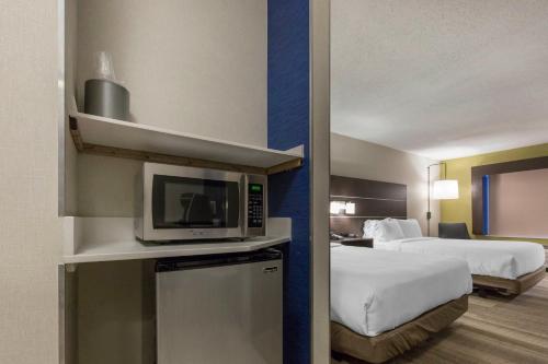 a hotel room with two beds and a microwave at Holiday Inn Express & Suites Chicago West - St Charles by IHG in Saint Charles