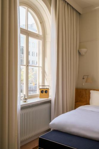 a bedroom with a bed and a window at Stockholm Stadshotell in Stockholm