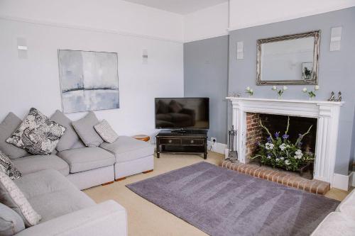 a living room with a couch and a fireplace at Leygreen Farmhouse B&B in Beaulieu