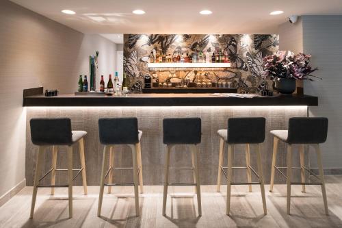 un bar con cuatro taburetes delante de un mostrador en Catalonia Magdalenes, en Barcelona