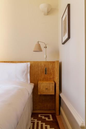 a bedroom with a bed and a lamp on a wall at Stockholm Stadshotell in Stockholm