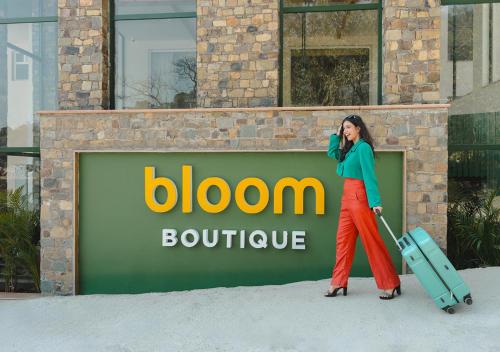 a woman talking on a cell phone while holding a suitcase at Bloom Boutique - Rishikesh Hills in Rishīkesh