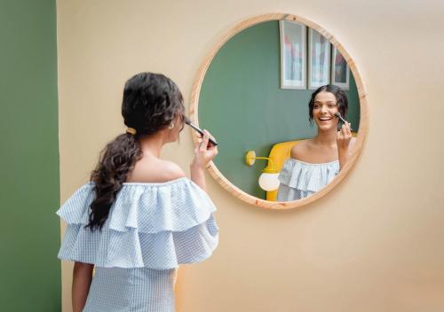 a young girl brushing her teeth in front of a mirror at Bloom Boutique - Rishikesh Hills in Rishīkesh
