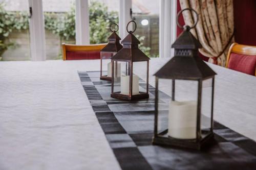 a table with three lanterns on top of a table at Leygreen Farmhouse B&B in Beaulieu