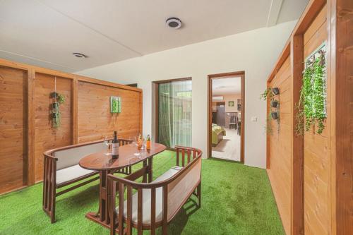 a dining room with a table and chairs and green grass at Park Hotel Bükfürdő in Bük