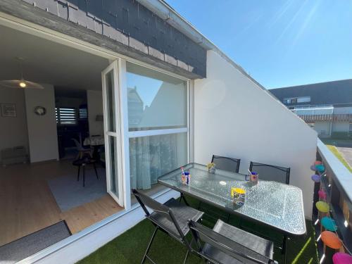 un patio avec une table et des chaises sur un balcon dans l'établissement Appartement les Capucins ROSCOFF, à Roscoff