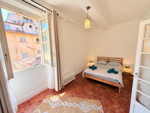une chambre avec un lit et une grande fenêtre dans l'établissement Typical Niçois apartment in the heart of old town, à Nice