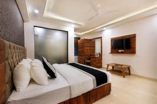 a bedroom with a large bed and a television at VERTTU Horizon Delhi Airport Free Airport Pick Up in New Delhi