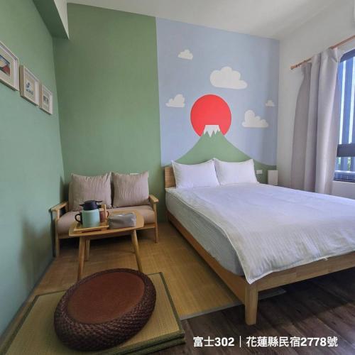 - une chambre avec un lit orné d'une fresque murale représentant la montagne dans l'établissement Kunba Homestay, à Hualien