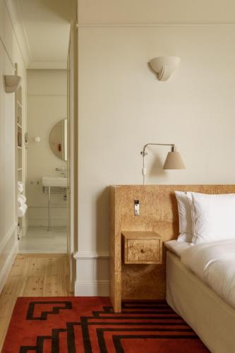 a bedroom with a bed with a table and a bathroom at Stockholm Stadshotell in Stockholm