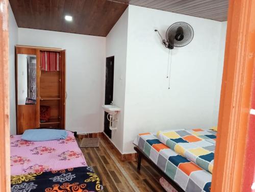a small bedroom with a bed and a window at Hotel Krushnai Athvan Farm House in Khamshet
