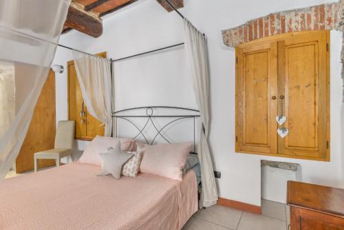 a bedroom with a pink bed and a wooden cabinet at Nido d'amore in Portoferraio