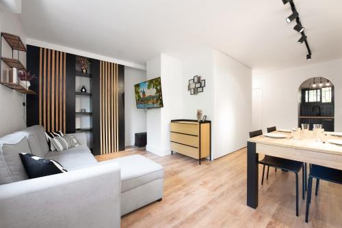 a living room with a white couch and a table at T2 - Havre paix 1à4p - Ramonville, Toulouse - Px Paul Sab & Labège - PKG in Ramonville-Saint-Agne