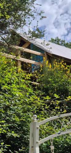 a building with a white fence and yellow flowers at Glamping Castel Dell'Aquila in Gragnola