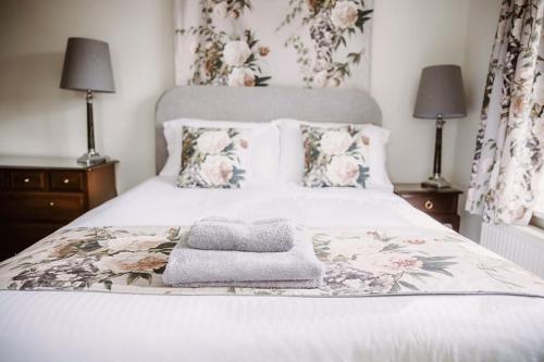 a bed with a blanket and pillows on it at Leygreen Farmhouse B&B in Beaulieu