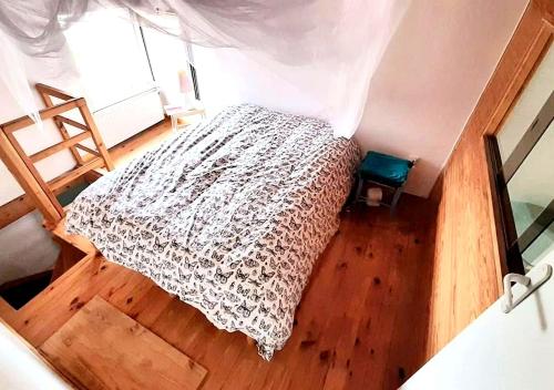 a bedroom with a bed and a wooden floor at Villa avec jardin et piscine privés in Montpellier