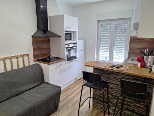 Una cocina con un sofá y una mesa en una habitación. en Grand T2 lumineux 2 pers Olivet Avenue Loiret, en Olivet