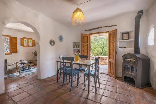 a dining room with a table and a wood stove at Off-Grid - Puerto Mika in Órgiva