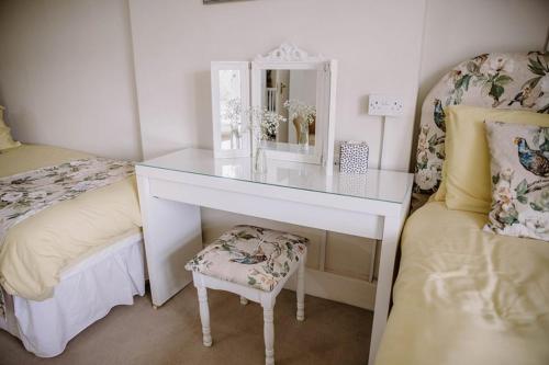 a white desk with a mirror and a chair in a bedroom at Leygreen Farmhouse B&B in Beaulieu