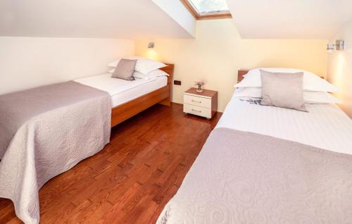 マリンスカにあるVilla Palace Clara Apartment 4 Island of Krk by Viの木製の床の部屋にベッドが2つあります