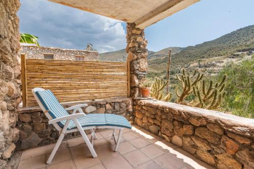 a blue and white chair sitting on a stone balcony at Off-Grid - Puerto Mika in Órgiva