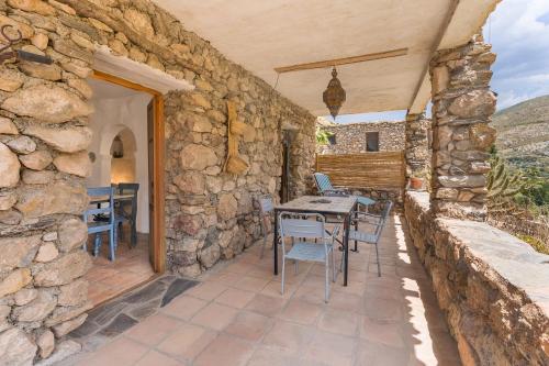 a stone building with a table and chairs on a patio at Off-Grid - Puerto Mika in Órgiva