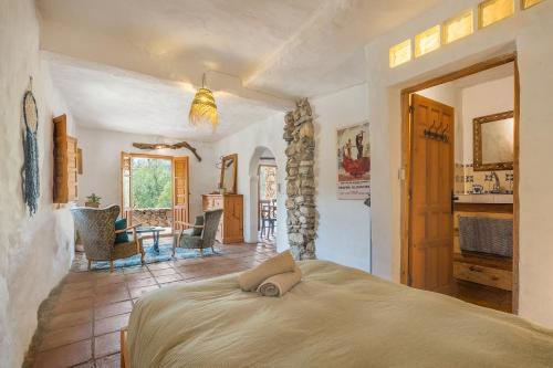 a bedroom with a bed and a table with chairs at Off-Grid - Puerto Mika in Órgiva