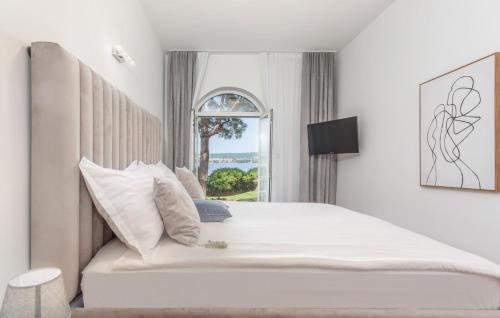 a bedroom with a large white bed with a window at Villa Palace Clara Apartment 6 island Krk by Villa in Malinska