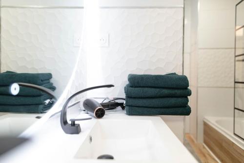 a bathroom with a mirror and green towels on a sink at T2 - Havre paix 1à4p - Ramonville, Toulouse - Px Paul Sab & Labège - PKG in Ramonville-Saint-Agne