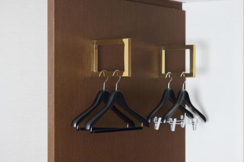 a closet with four hangers on a wall at Kobe Sannomiya Tokyu REI Hotel in Kobe