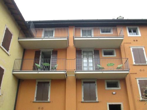 an orange building with balconies and plants on it at Ex dimora di Lawrence in Gargnano