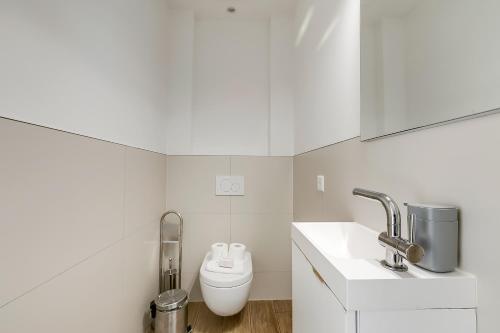 a white bathroom with a toilet and a sink at Viganello Modern Apartments in Lugano