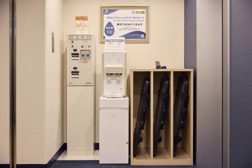 a room with a refrigerator and a shelf with baseball bats at Kobe Sannomiya Tokyu REI Hotel in Kobe