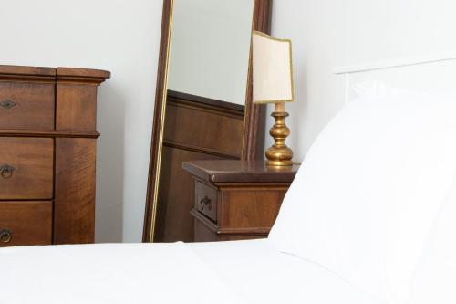 a bedroom with a dresser and a lamp and a mirror at Welc-ōM Montegrotto Terrace View in Montegrotto Terme