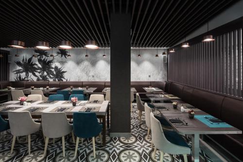 a dining room with long tables and blue chairs at Catalonia Magdalenes in Barcelona