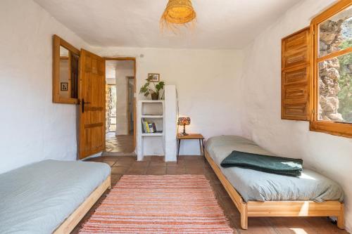 a bedroom with two beds and a window at Off-Grid - Puerto Mika in Órgiva