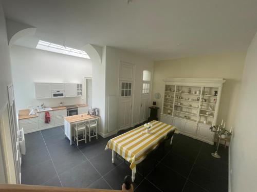 una grande stanza con cucina con tavolo di Maison d'hôte L'Esperance chic et calme a Saint-Omer