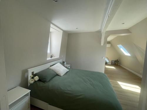 una camera con un letto verde e una scala di Maison d'hôte L'Esperance chic et calme a Saint-Omer