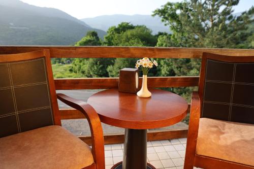 a wooden table with a vase of flowers on a balcony at Dilijan Park Resort & Villas in Dilijan
