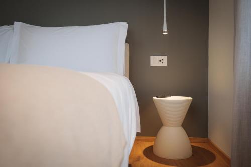 a bed with a white pillow and a vase in a room at Villa Amelia in Orta San Giulio