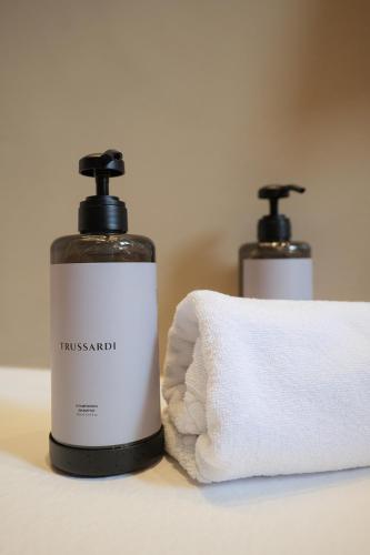 two bottles of toiletries sitting next to a pile of towels at Villa Amelia in Orta San Giulio