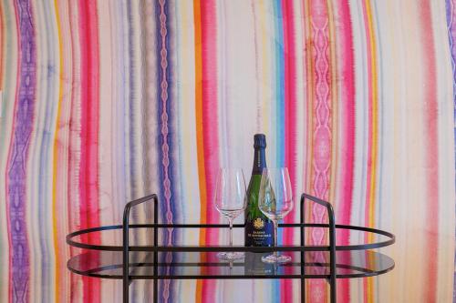 a glass table with a bottle of wine and two glasses at Villa Amelia in Orta San Giulio