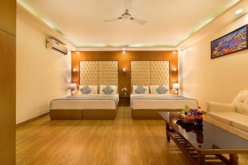 a hotel room with two beds and a couch at VIVVA Premier Delhi Aerocity FREE Airport Pick Up in New Delhi