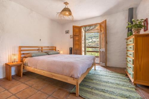 a bedroom with a large bed and a window at Off-Grid - Puerto Mika in Órgiva