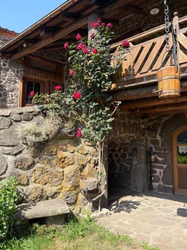 a stone house with flowers on the side of it at Le Bouffadou in Le Bouchet-Saint-Nicolas