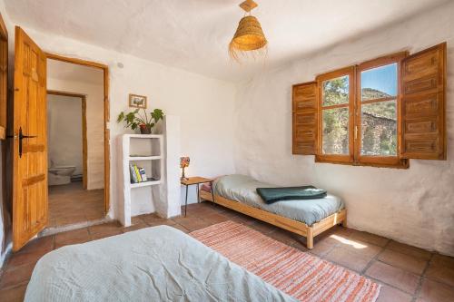 a bedroom with a bed and a window at Off-Grid - Puerto Mika in Órgiva